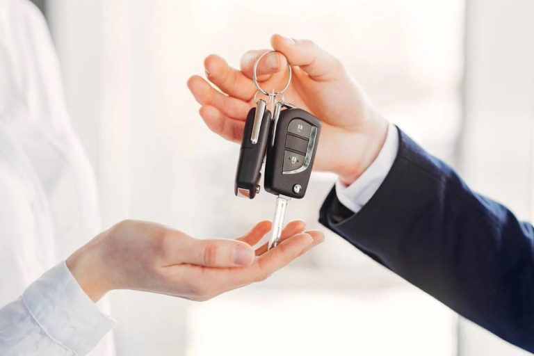Close-up of a car key handover during a vehicle sale
